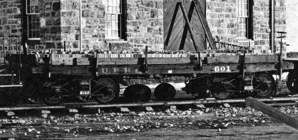 UP Flat #601 alongside the roundhouse in Laramie, WY. Cropped from an A.J. Russell photograph.